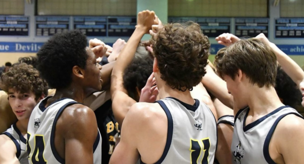 The Boys Basketball team celebrate their impressive, season-opening win.