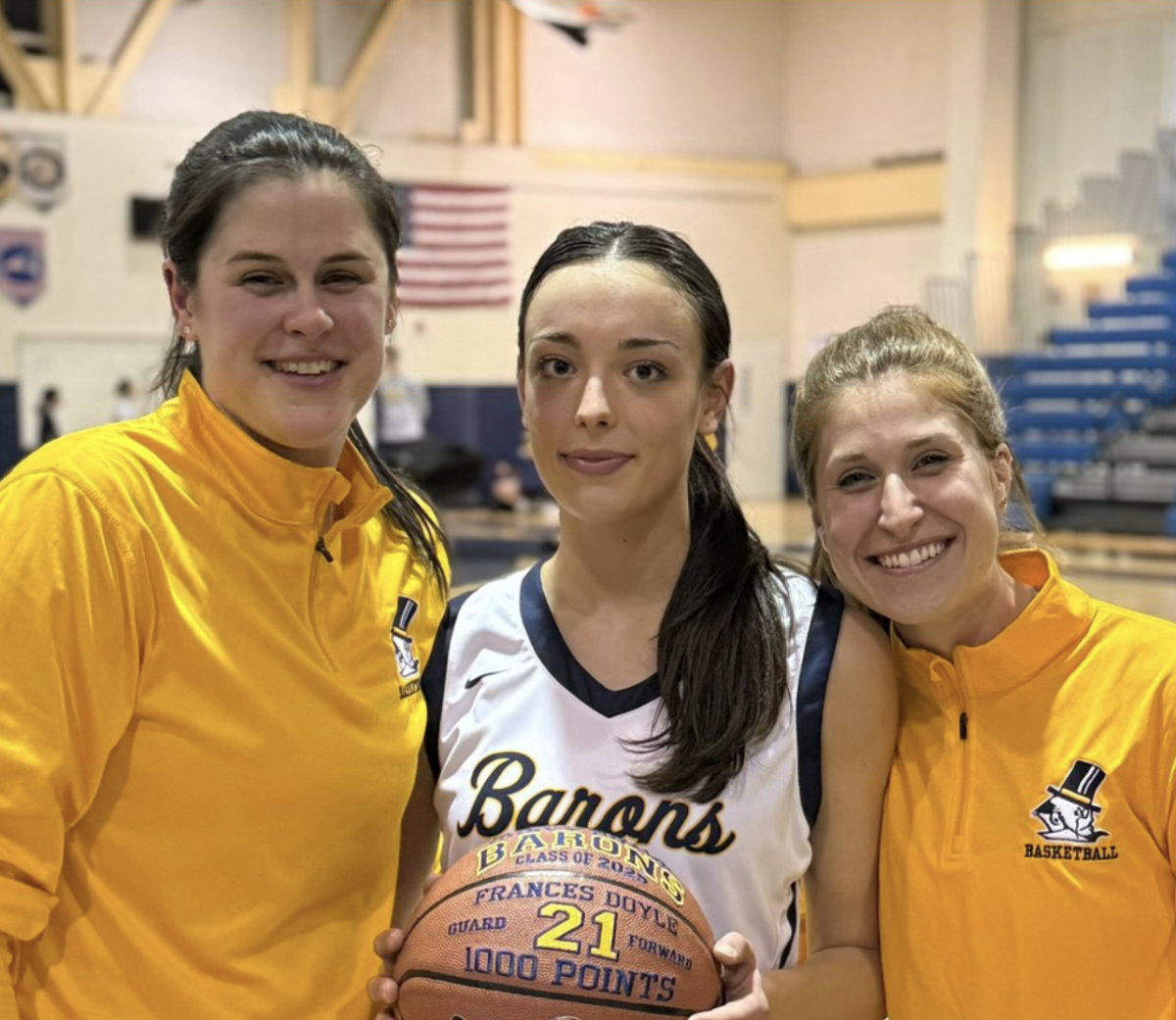 Senior Frances Doyle (middle) posing with her coaches, Coach Ingalls (left) and Coach Fitz (right) after celebrating her 1000th career point. Photo courtesy of @Barons_Bball. 