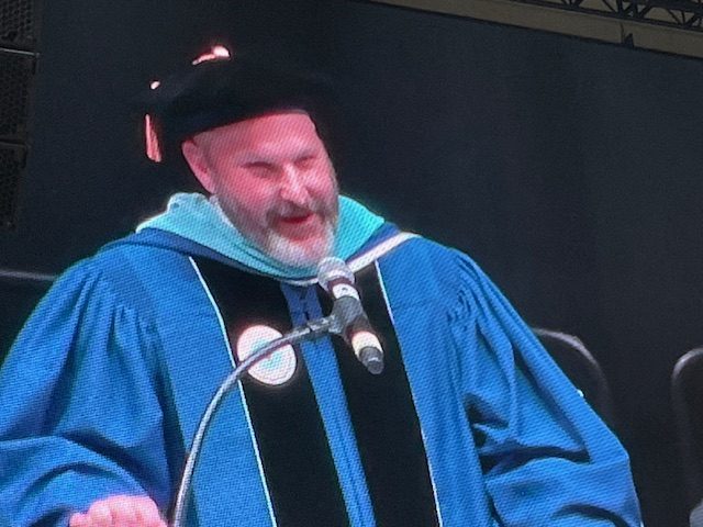 Dr. Mooney addresses graduates on the importance of writing one's story from the podium and the big screen.